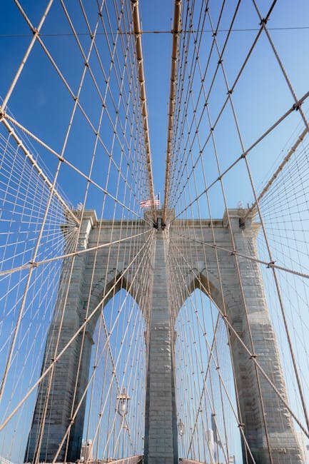 Stunning view of Brooklyn Bridge cables against a clear blue sky. Urban adventure.